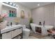 Stylish bathroom with a modern vanity, sleek white soaking tub, and patterned accent wall at 11119 W Mountain View Rd, Sun City, AZ 85351