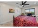 Bright bedroom featuring a ceiling fan, neutral walls, and a unique, patterned bedspread at 11119 W Mountain View Rd, Sun City, AZ 85351
