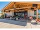 Stunning front entrance with exposed wood beams, black-framed windows, and ample seating on the spacious porch at 11119 W Mountain View Rd, Sun City, AZ 85351