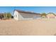 Detached garage with a white exterior, roll-up door, and ample parking space, complemented by desert landscaping at 11119 W Mountain View Rd, Sun City, AZ 85351
