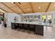 Bright kitchen featuring a large island with seating, sleek white cabinets, modern appliances and wooden vaulted ceilings at 11119 W Mountain View Rd, Sun City, AZ 85351