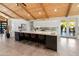 Bright kitchen featuring a large island with seating, sleek white cabinets, modern appliances and wooden vaulted ceilings at 11119 W Mountain View Rd, Sun City, AZ 85351