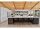 Bright kitchen featuring a large island with seating, sleek white cabinets, modern appliances and wooden vaulted ceilings at 11119 W Mountain View Rd, Sun City, AZ 85351