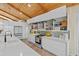 Modern kitchen with sleek white cabinets, stainless steel appliances, quartz countertops and wooden vaulted ceilings at 11119 W Mountain View Rd, Sun City, AZ 85351