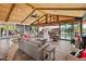 Inviting living room boasts vaulted wood ceiling, comfortable seating, and expansive windows with backyard views at 11119 W Mountain View Rd, Sun City, AZ 85351