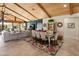 Bright living room with vaulted wood ceiling, tile floors, and large windows overlooking outdoor living space at 11119 W Mountain View Rd, Sun City, AZ 85351