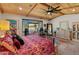 Bright main bedroom with a ceiling fan, a window view, dresser, and seating area at 11119 W Mountain View Rd, Sun City, AZ 85351