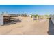 Gated entrance to a sprawling property featuring a rustic fence and a long driveway leading to multiple buildings at 11119 W Mountain View Rd, Sun City, AZ 85351