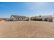 Wide view of the property showcasing multiple buildings, mature trees, and an open gravel area, ideal for development at 11119 W Mountain View Rd, Sun City, AZ 85351