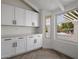 Bright kitchen featuring white cabinets, subway tile backsplash, herringbone floors and large window with pergola view at 14639 N 55Th Pl, Scottsdale, AZ 85254