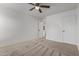 Bedroom featuring a ceiling fan and neutral carpeting, leading to a hallway at 16215 W Durango St, Goodyear, AZ 85338