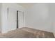 This bedroom has neutral carpet, blank walls, and a closet with white doors at 16215 W Durango St, Goodyear, AZ 85338