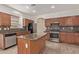 Traditional kitchen with granite countertops, wood cabinets, stainless steel appliances, and wood-look tile flooring at 16215 W Durango St, Goodyear, AZ 85338