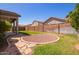 Well-maintained backyard with a gravel firepit, manicured lawn, and block fence for privacy at 16768 W Nottingham Way, Surprise, AZ 85374
