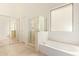 Bathroom features a soaking tub, glass enclosed shower, and white cabinets at 16768 W Nottingham Way, Surprise, AZ 85374