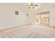 Bright bedroom featuring carpet flooring, a ceiling fan, and natural light from several windows at 16768 W Nottingham Way, Surprise, AZ 85374