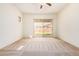 Neutral bedroom with carpet flooring, ceiling fan, and sliding glass door to the backyard at 16768 W Nottingham Way, Surprise, AZ 85374