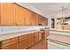 Spacious kitchen features wood cabinets, counters, and a breakfast bar overlooking the adjacent room at 16768 W Nottingham Way, Surprise, AZ 85374