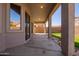 Covered patio leading out to a backyard with lush green grass and stone walkway at 16768 W Nottingham Way, Surprise, AZ 85374