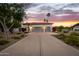 Charming home with a three-car garage at dusk, featuring well-manicured landscaping at 10380 E Cholla St, Scottsdale, AZ 85260