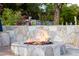A stone fire pit becomes the focal point in a beautifully landscaped backyard at 10380 E Cholla St, Scottsdale, AZ 85260
