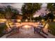 Inviting stone fire pit with built-in seating, creating a warm and relaxing outdoor entertainment space at 10380 E Cholla St, Scottsdale, AZ 85260