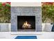 Outdoor fireplace with unique tiling and comfortable seating area at 10380 E Cholla St, Scottsdale, AZ 85260