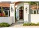 Elegant front entrance with a tiled roof, wooden door, and decorative sconces nestled within a charming garden setting at 10380 E Cholla St, Scottsdale, AZ 85260