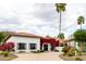 Single-story home with a tile roof, desert landscaping, and mature bougainvillea climbing near the entrance at 10380 E Cholla St, Scottsdale, AZ 85260