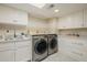 Well-organized laundry room with front loading washer and dryer and plenty of cabinet space at 10380 E Cholla St, Scottsdale, AZ 85260