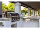 This outdoor kitchen boasts a stainless steel grill built into a concrete island under a covered patio at 10380 E Cholla St, Scottsdale, AZ 85260