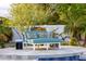 Inviting turquoise poolside lounge seating features decorative pillows, perfect for outdoor relaxation at 10380 E Cholla St, Scottsdale, AZ 85260