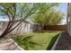 This serene backyard boasts artificial grass and mature trees, creating a private and relaxing outdoor space at 14114 W Surrey Dr, Surprise, AZ 85379