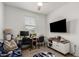 Well-lit bedroom featuring a sleek workspace, a comfy sofa, and a mounted television for entertainment at 14114 W Surrey Dr, Surprise, AZ 85379
