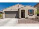 Inviting single-story home featuring a neutral stucco exterior, two-car garage, and a charming covered entry with a warm wood door at 14114 W Surrey Dr, Surprise, AZ 85379