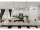 Bright kitchen with island, granite counters, modern lighting and stainless steel appliances at 14114 W Surrey Dr, Surprise, AZ 85379