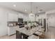 Modern kitchen with granite countertops, stainless steel appliances, white cabinetry, and a stylish island with seating at 14114 W Surrey Dr, Surprise, AZ 85379