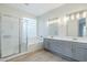 Well-lit bathroom boasts a dual sink vanity, separate shower, and soaking tub with glass block window for natural light at 1584 E Harrison E St, Chandler, AZ 85225