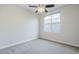 A bright bedroom features plush carpeting, a ceiling fan, and a large window offering ample natural light at 1584 E Harrison E St, Chandler, AZ 85225