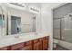Bathroom with double vanity sinks, a large mirror, and separate shower/toilet area at 16753 W Bristol Ln, Surprise, AZ 85374