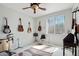 Bedroom/music room with carpet, ceiling fan, and several guitars hanging on the wall at 16753 W Bristol Ln, Surprise, AZ 85374