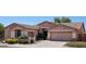 Beautiful single-story home with a two-car garage and lush front yard landscaping at 16753 W Bristol Ln, Surprise, AZ 85374