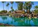 Entrance to Sun Village featuring lush landscaping, a tranquil pond, and palm trees at 17119 N Joshua Path, Surprise, AZ 85374