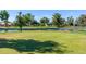 Well-maintained golf course with a pond, flag, and lush green grass under a clear blue sky at 17119 N Joshua Path, Surprise, AZ 85374
