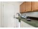 Bright laundry room with overhead cabinets and adjacent door to the exterior at 17119 N Joshua Path, Surprise, AZ 85374