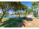 Picturesque pond and walking bridge framed by mature trees and manicured lawns at 17119 N Joshua Path, Surprise, AZ 85374