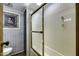 Compact bathroom with a shower and a toilet, with gray washed wood paneled walls and a stone themed accent picture at 17200 W Bell Rd # 324, Surprise, AZ 85374