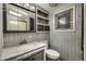 Well lit bathroom with stone accents above a toilet, a vanity, and a shower behind glass doors at 17200 W Bell Rd # 324, Surprise, AZ 85374