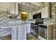 Functional kitchen featuring stainless steel appliances, ample counter space and gray washed wood paneled walls at 17200 W Bell Rd # 324, Surprise, AZ 85374