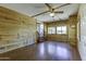 Living room with wood paneling, hardwood floors, ceiling fan, and staircase at 17200 W Bell Rd # 324, Surprise, AZ 85374